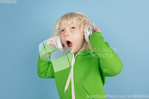 Image of Portrait of beautiful caucasian little boy isolated on blue studio background