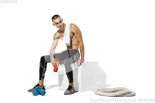 Image of Beautiful young male athlete practicing on white studio background with shadows