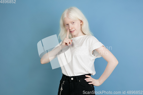 Image of Portrait of beautiful caucasian albino girl isolated on blue studio background