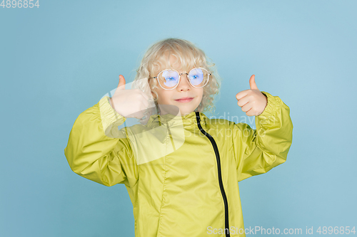 Image of Portrait of beautiful caucasian little boy isolated on blue studio background