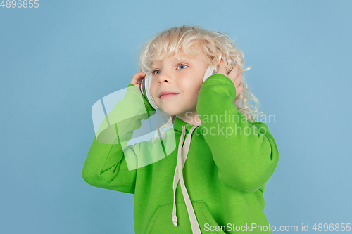 Image of Portrait of beautiful caucasian little boy isolated on blue studio background