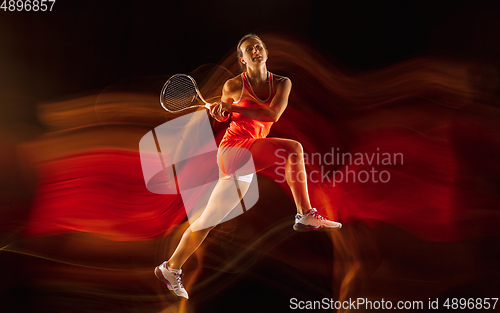 Image of Professional female tennis player isolated on black studio background in mixed light