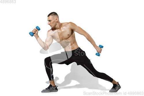 Image of Beautiful young male athlete practicing on white studio background with shadows