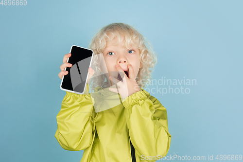 Image of Portrait of beautiful caucasian little boy isolated on blue studio background