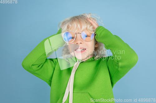 Image of Portrait of beautiful caucasian little boy isolated on blue studio background