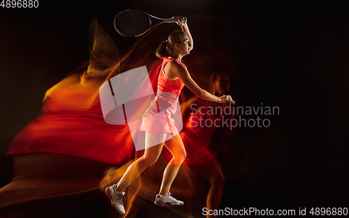 Image of Professional female tennis player isolated on black studio background in mixed light