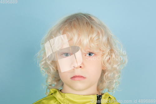 Image of Portrait of beautiful caucasian little boy isolated on blue studio background