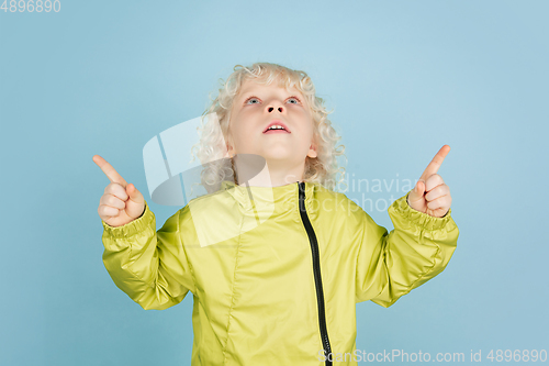 Image of Portrait of beautiful caucasian little boy isolated on blue studio background