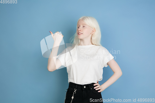 Image of Portrait of beautiful caucasian albino girl isolated on blue studio background