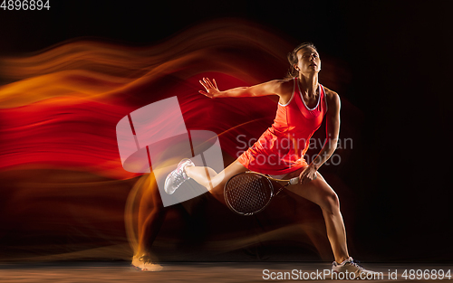 Image of Professional female tennis player isolated on black studio background in mixed light