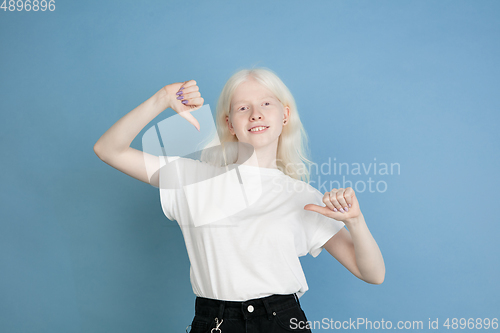Image of Portrait of beautiful caucasian albino girl isolated on blue studio background