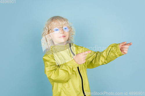 Image of Portrait of beautiful caucasian little boy isolated on blue studio background