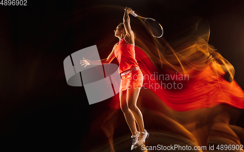 Image of Professional female tennis player isolated on black studio background in mixed light