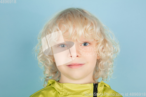 Image of Portrait of beautiful caucasian little boy isolated on blue studio background