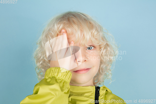 Image of Portrait of beautiful caucasian little boy isolated on blue studio background