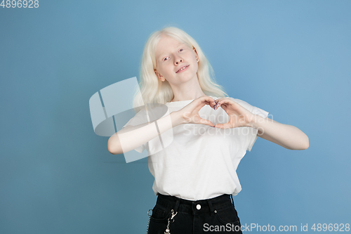 Image of Portrait of beautiful caucasian albino girl isolated on blue studio background