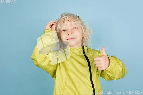 Image of Portrait of beautiful caucasian little boy isolated on blue studio background