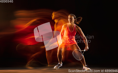 Image of Professional female tennis player isolated on black studio background in mixed light