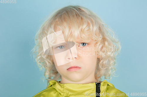 Image of Portrait of beautiful caucasian little boy isolated on blue studio background
