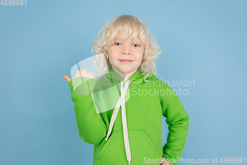 Image of Portrait of beautiful caucasian little boy isolated on blue studio background