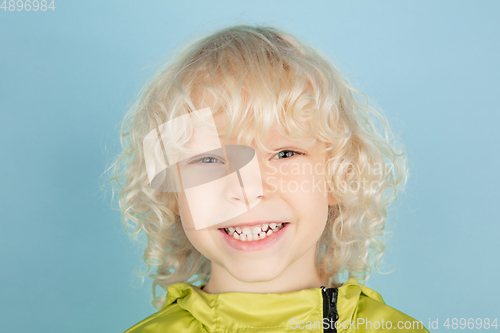 Image of Portrait of beautiful caucasian little boy isolated on blue studio background