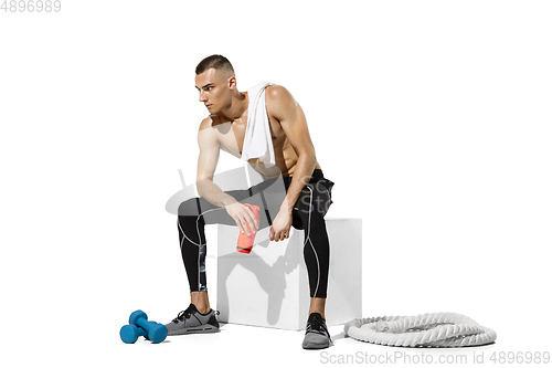 Image of Beautiful young male athlete practicing on white studio background with shadows