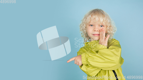 Image of Portrait of beautiful caucasian little boy isolated on blue studio background