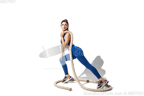 Image of Beautiful young female athlete practicing on white studio background with shadows