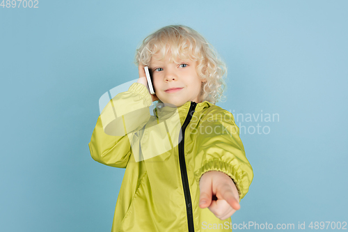 Image of Portrait of beautiful caucasian little boy isolated on blue studio background