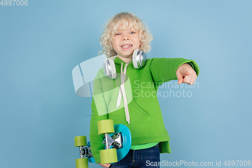 Image of Portrait of beautiful caucasian little boy isolated on blue studio background