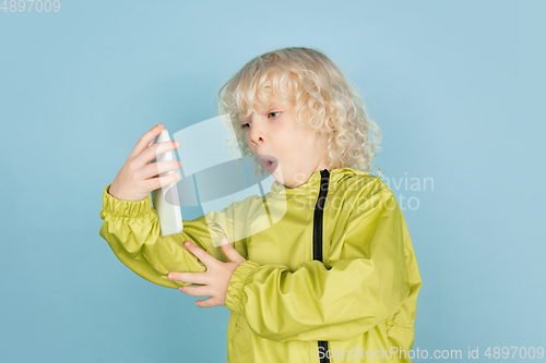 Image of Portrait of beautiful caucasian little boy isolated on blue studio background