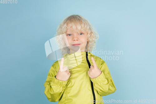 Image of Portrait of beautiful caucasian little boy isolated on blue studio background