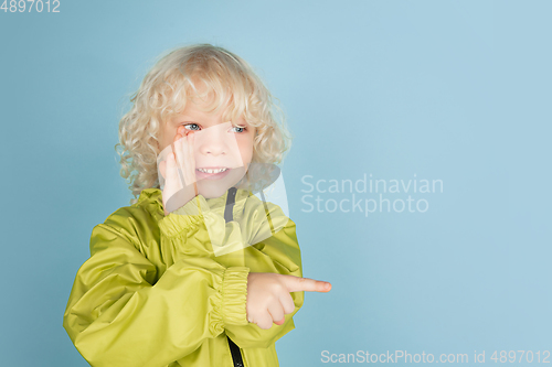 Image of Portrait of beautiful caucasian little boy isolated on blue studio background