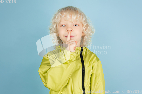 Image of Portrait of beautiful caucasian little boy isolated on blue studio background