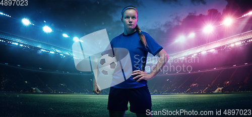 Image of Football or soccer player on full stadium and flashlights background