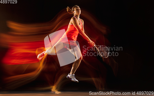 Image of Professional female tennis player isolated on black studio background in mixed light