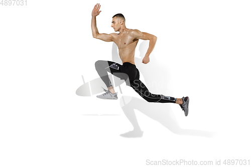 Image of Beautiful young male athlete practicing on white studio background with shadows