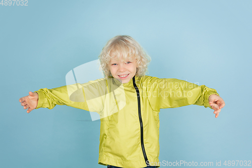 Image of Portrait of beautiful caucasian little boy isolated on blue studio background