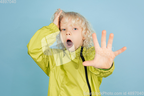 Image of Portrait of beautiful caucasian little boy isolated on blue studio background