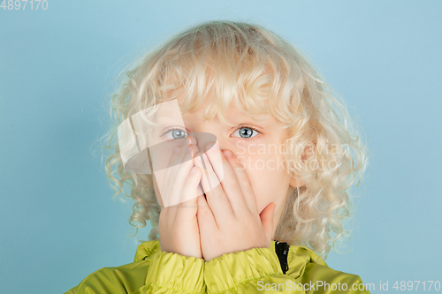 Image of Portrait of beautiful caucasian little boy isolated on blue studio background