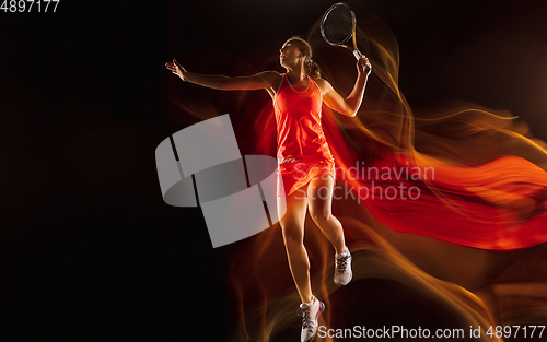 Image of Professional female tennis player isolated on black studio background in mixed light