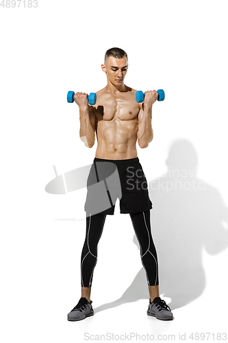 Image of Beautiful young male athlete practicing on white studio background with shadows