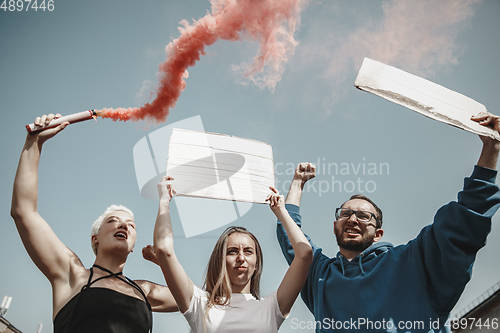 Image of Group of activists giving slogans in a rally. Men and women marching together in a protest in the city.