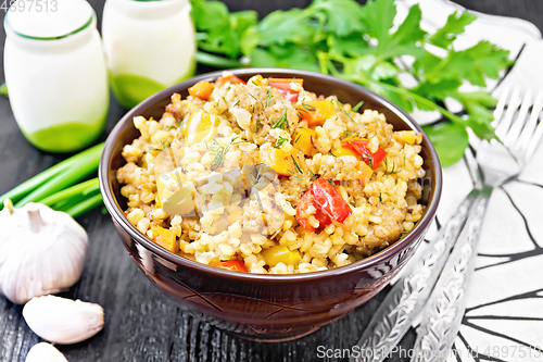 Image of Barley porridge with minced meat in bowl on dark board