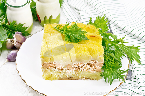 Image of Casserole with potatoes and fish in plate on board