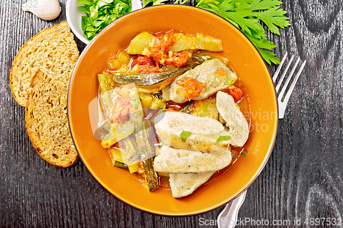 Image of Chicken with stewed zucchini in plate on board top