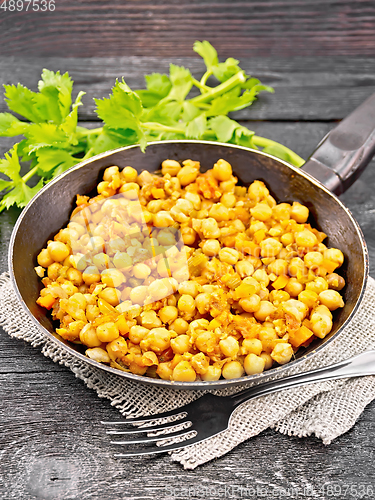 Image of Chickpeas stewed with vegetables in pan on black board