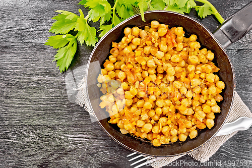 Image of Chickpeas stewed with vegetables in pan on board top