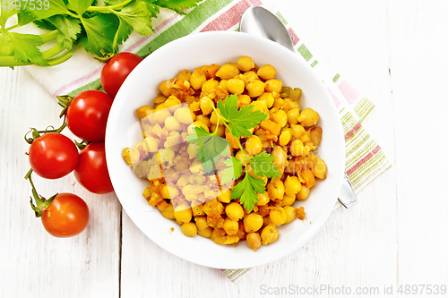 Image of Chickpeas stewed with vegetables in plate on board top