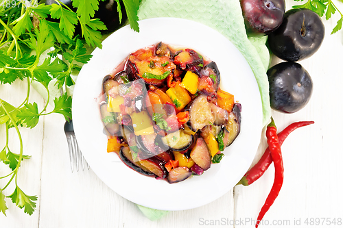 Image of Eggplant with plums in plate on board top